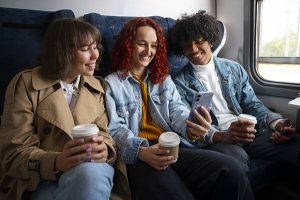 Des amis dans le train pour partir en vacances grâce aux réductions sur le prix des billets.