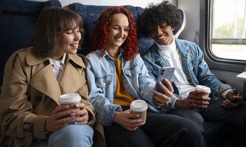 Des amis dans le train pour partir en vacances grâce aux réductions sur le prix des billets.