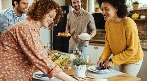 Des amis cuisinent et mettent la table pour un repas pendant les vacances.