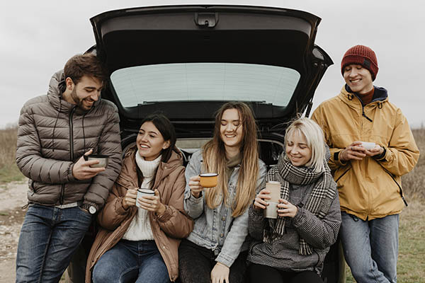 Des amis en road trip font une pause café sur la route.