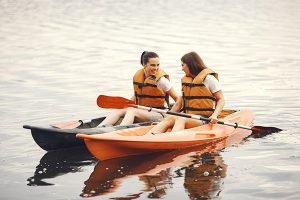 Des amies font du canoe sur un lac en France.